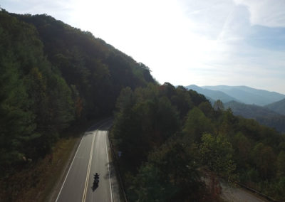 A motorcycle rides along a winding road