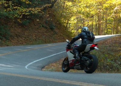 A motorcyclist leans into a winding road