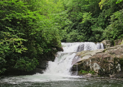 A serene waterfall cascades over rocky terrain