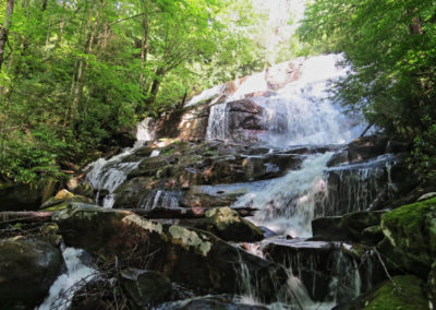 A cascading waterfall flows over moss-covered rocks