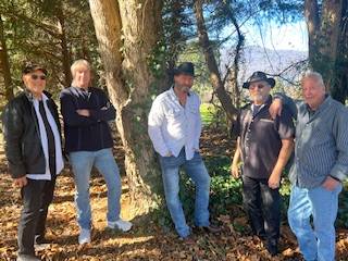 Five men standing together in a wooded area
