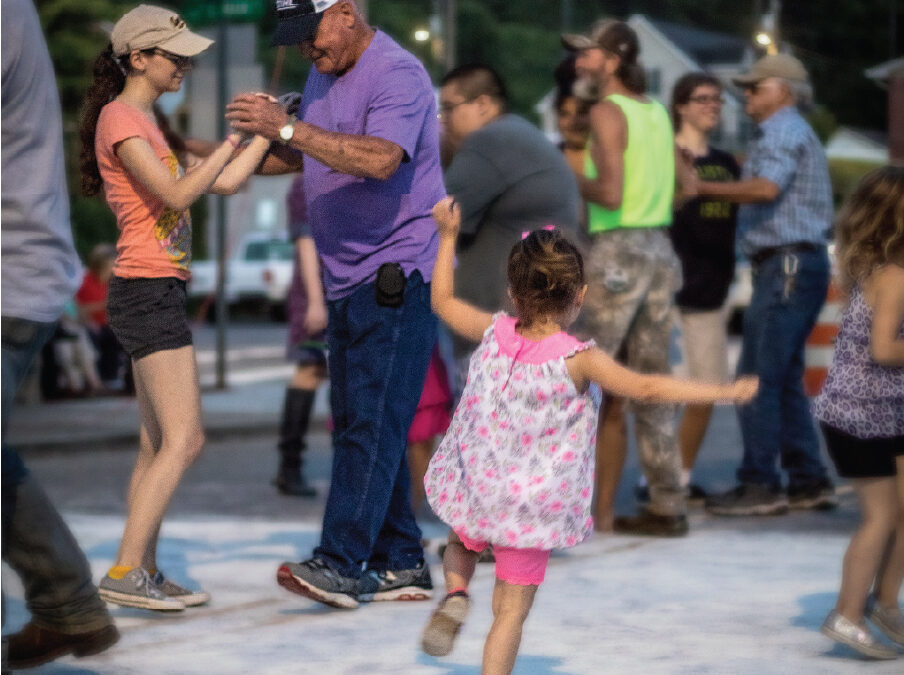 Multigenerational dancers on the cornmeal dusted street at Dancing on the Square in Robbinsville, NC.